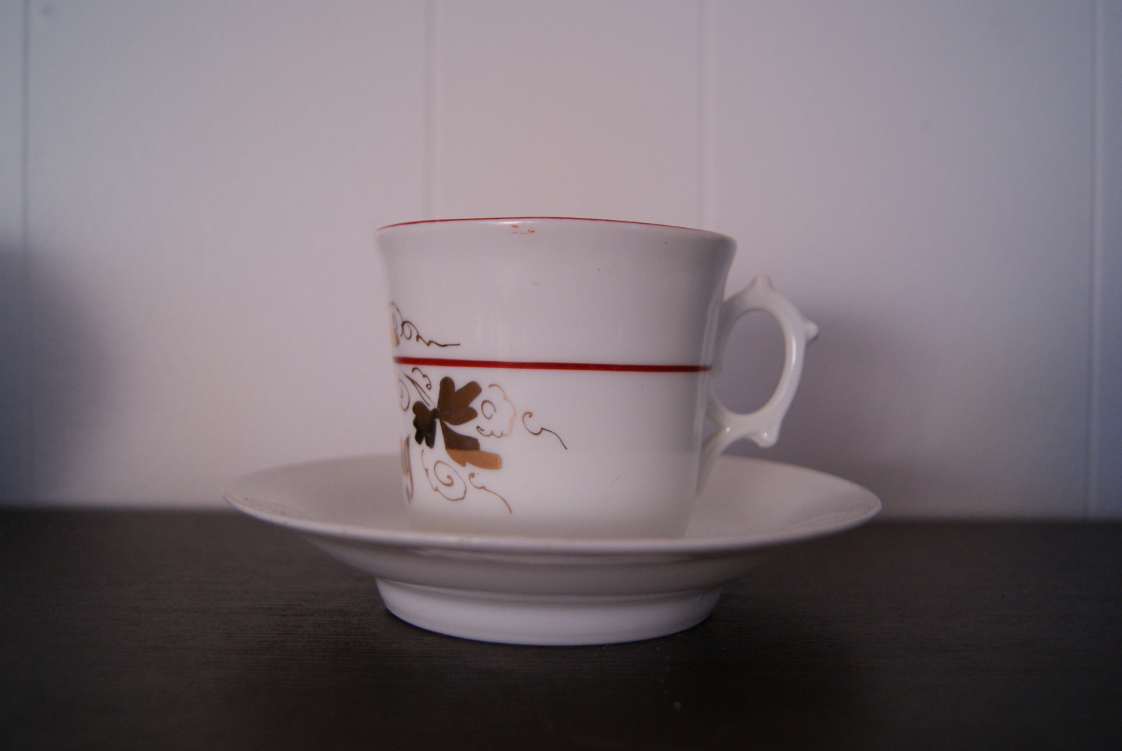 Porsgrund kopp med skål, gull dekor, rødt bånd og inskripsjon: 