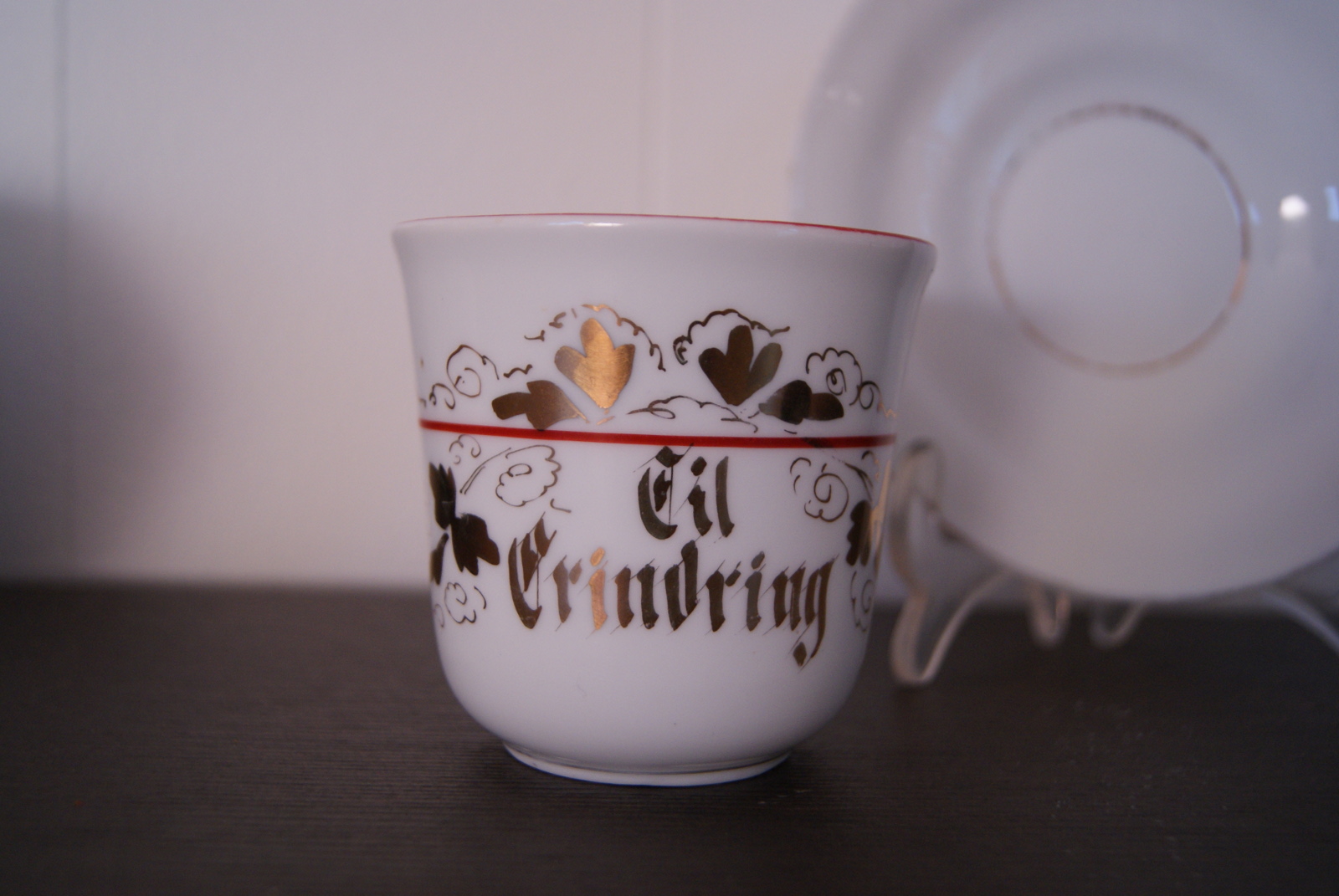 Porsgrund kopp med skål, gull dekor, rødt bånd og inskripsjon: 