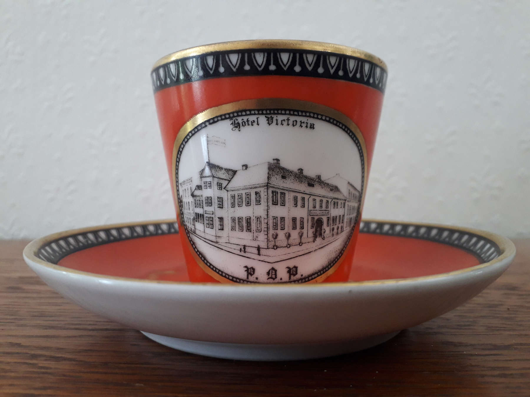 Porsgrund cup with saucer in red colour and with Hotel Victoria decor.